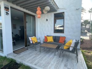 a patio with chairs and a couch on a deck at Apartamerica 471, Gartenwohnung, Pool, 150 M zum Strand, Las Americas in Costa de Adeje