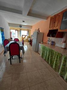 cocina y comedor con mesa y nevera en Refugio del Viento, en Gobernador Gregores