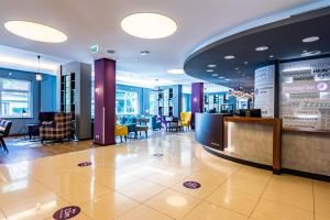 a lobby with a bar and tables and chairs at Premier Inn Hamburg City Alster in Hamburg