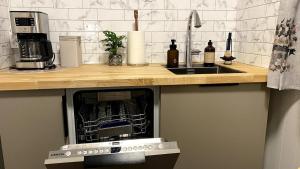 a kitchen with a counter with a sink and a microwave at Sjelefred - Ocean Suite in Sortland