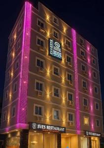 un edificio con luces púrpuras en el lateral. en Mehmaan Guest House, en Hyderabad