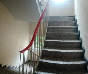 a staircase in a building with a red railing at Gemütliches Zimmer mit gemeinsamem WC in Oberhausen Osterfeld-Mitte in Oberhausen