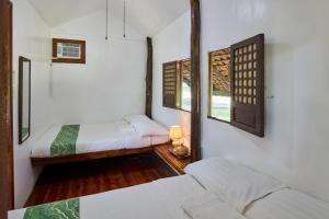 pokój z dwoma łóżkami i oknem w obiekcie Almost Heaven Lake Resort w mieście Cavinti