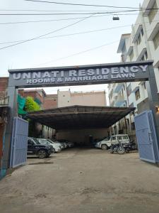a parking lot with cars parked under a building at Unnati Residency in Varanasi