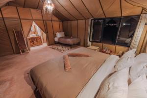 a bedroom with a bed in a tent at Sahara Camp Excursions in Merdani
