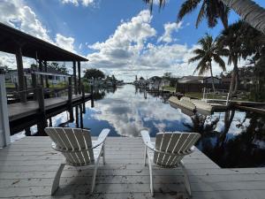 two chairs sitting on a dock next to a body of water at Tarpon - Spacious Updated W&D Full Kitchen 1.5 Mi to Beach in Bonita Springs