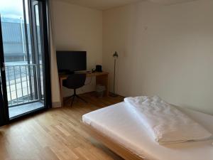 a bedroom with a bed and a desk with a computer at Herburger Living in Dornbirn