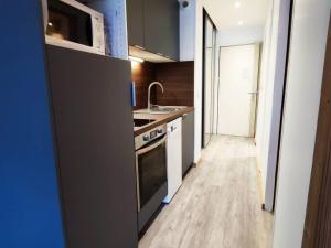a kitchen with a sink and a stove top oven at Appartement Rénové 2P avec Balcon Sud, Front de Neige, au Pied des Pistes - FR-1-292-64 in Isola 2000 +3 photos