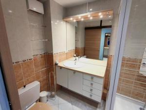 a bathroom with a sink and a toilet and a mirror at Appartement Rénové 2P avec Balcon Sud, Front de Neige, au Pied des Pistes - FR-1-292-64 in Isola 2000