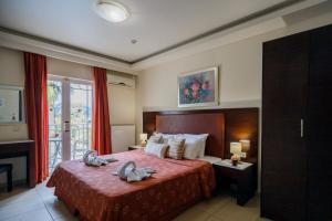 a bedroom with a bed with two swans on it at Vivian Hotel in Laganas +46 photos