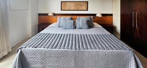 une chambre avec un grand lit avec des oreillers bleus dans l'établissement Prime Flat II - Metrópolis Alphaville, à Barueri 15 autres photos