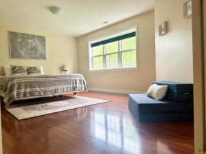 フレデリクトンにあるCozy guest suite in the heart of Frederictonのベッドとソファと窓のある寝室