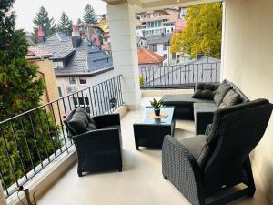 a balcony with a couch and chairs and a table at Layla's Home Free Parking in Sarajevo
