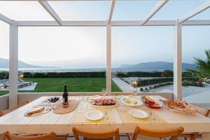 una mesa blanca con comida y vino en el patio en Akti Villa, en Kissamos