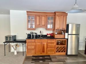 フレデリクトンにあるCozy guest suite in the heart of Frederictonのキッチン(木製キャビネット、ステンレス製の冷蔵庫付) +16枚の写真