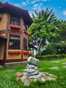 a teddy bear sitting in the grass in front of a house at Pousada Viking Penedo in Penedo