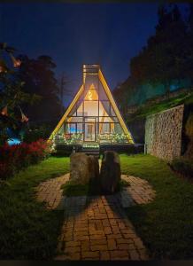 een klein huis met een glazen gevel in de nacht bij Lux Lake View Aframe - Skyframe in Kodaikānāl