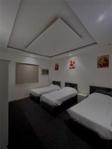 a bedroom with two beds and a large ceiling at شقه مفروشه المدينة المنورة in Al Madinah