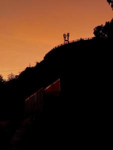 een hek op de top van een heuvel bij zonsondergang bij Lux Lake View Aframe - Skyframe in Kodaikānāl