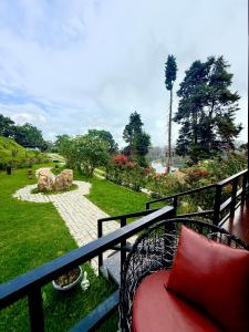 een balkon met een bank en uitzicht op een park bij Lux Lake View Aframe - Skyframe in Kodaikānāl