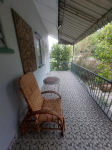 una silla de mimbre sentada en el balcón de una casa en A Borneo Guesthouse, en Johor Bahru