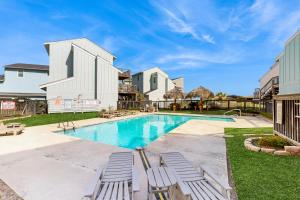 a swimming pool with lounge chairs in a yard at Colony Make A Splash in Padre Island