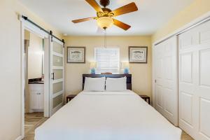a bedroom with a bed and a ceiling fan at Colony Make A Splash in Padre Island +17 photos
