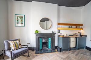 a living room with a fireplace and a mirror at Crescent Place by Mansley in Cheltenham