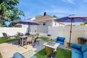 Un patio con mesa, sillas y sombrillas. en MC Beach Getaway, en Pottawattamie Park
