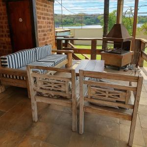 a patio with a bench and a table and a grill at Estância Pontello - próximo ao aeroporto de Confins in Confins