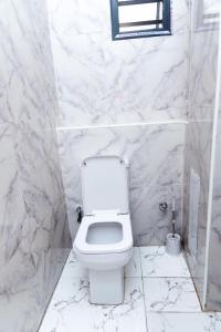 a white bathroom with a toilet and a window at Luxury 3BR Apt w balcony view in Chevron, Lekki in Lekki