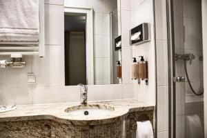 a bathroom with a sink and a shower at Hotel Fuchs Saarbrücken in Saarbrücken