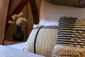 a pillow on a bed with a vase of flowers at Hotel Fuchs Saarbrücken in Saarbrücken