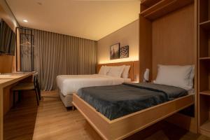 a hotel room with two beds and a desk at Golden Tulip Canela in Canela