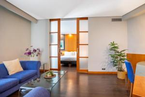 a living room with a blue couch and a glass table at Eurostars Atlántida in Santa Cruz de Tenerife