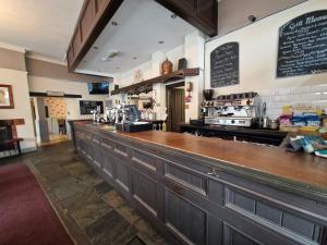 a bar in a restaurant with a counter at The Swan Hotel in Lydney