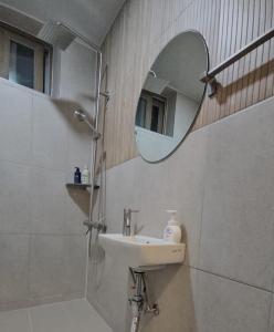 a bathroom with a sink and a mirror at 에어진주 AirJINJU in Jinju