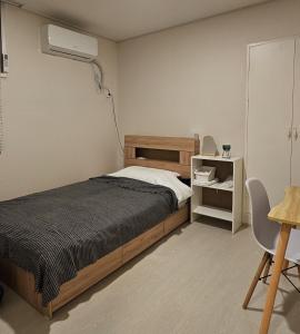 a bedroom with a bed and a air conditioner at 에어진주 AirJINJU in Jinju