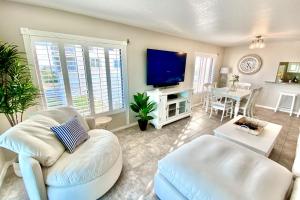 a living room with a couch and a tv at Sailfish Sands in Cocoa Beach