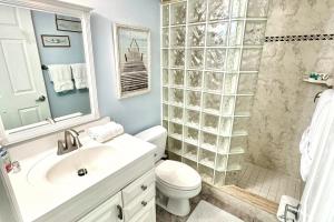 a bathroom with a toilet and a sink and a shower at Sailfish Sands in Cocoa Beach +42 photos
