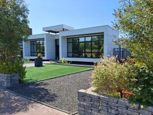 a white house with black windows and a yard at B&B DownUnder in Vlissingen