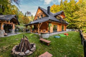 een blokhut met een speeltuin in de tuin bij Chata na Skarpie - SPA i widok na Skrzyczne in Szczyrk