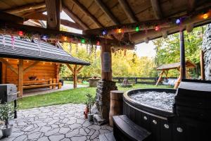 een patio met een hottub en een houten paviljoen bij Chata na Skarpie - SPA i widok na Skrzyczne in Szczyrk
