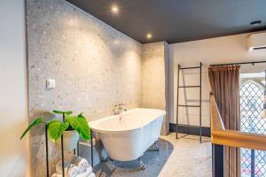 a bathroom with a tub and a plant in it at Crescent Place by Mansley in Cheltenham +61 photos