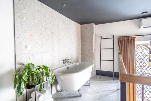 a bathroom with a white tub and a potted plant at Crescent Place by Mansley in Cheltenham +59 photos