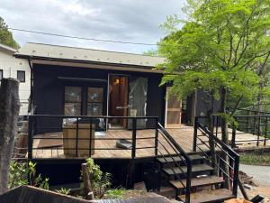 a black tiny house with a porch and stairs at 箱根強羅 縁 in Hakone +16 photos