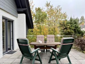 a wooden table and four chairs on a patio at Ferienhaus Sonnenblick in Heringhausen