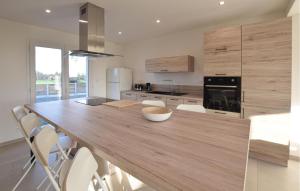 a kitchen with a large wooden table with white chairs at Awesome Home In Bacilly With Wifi in Bacilly