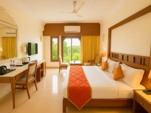 a hotel room with a bed and a desk at Hotel Hilltop Palace in Udaipur