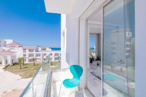 a blue chair on a balcony with a view of the ocean at Azur in Bin Rhilouf